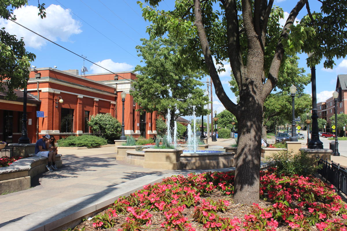 Downtown Downers Grove, Illinois — brick train station, fountain, and flower beds on a summer day
